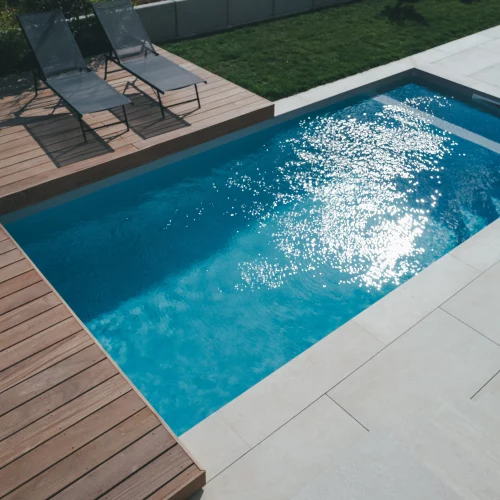 Terrasse en bois exotique Cumaru avec deux bains de soleil aux abord d'une piscine